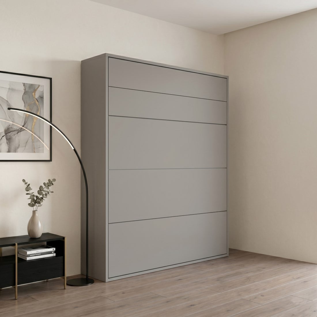 Tall gray wardrobe with horizontal drawers in a minimalist bedroom, beside a black console table with a vase and a curved floor lamp.