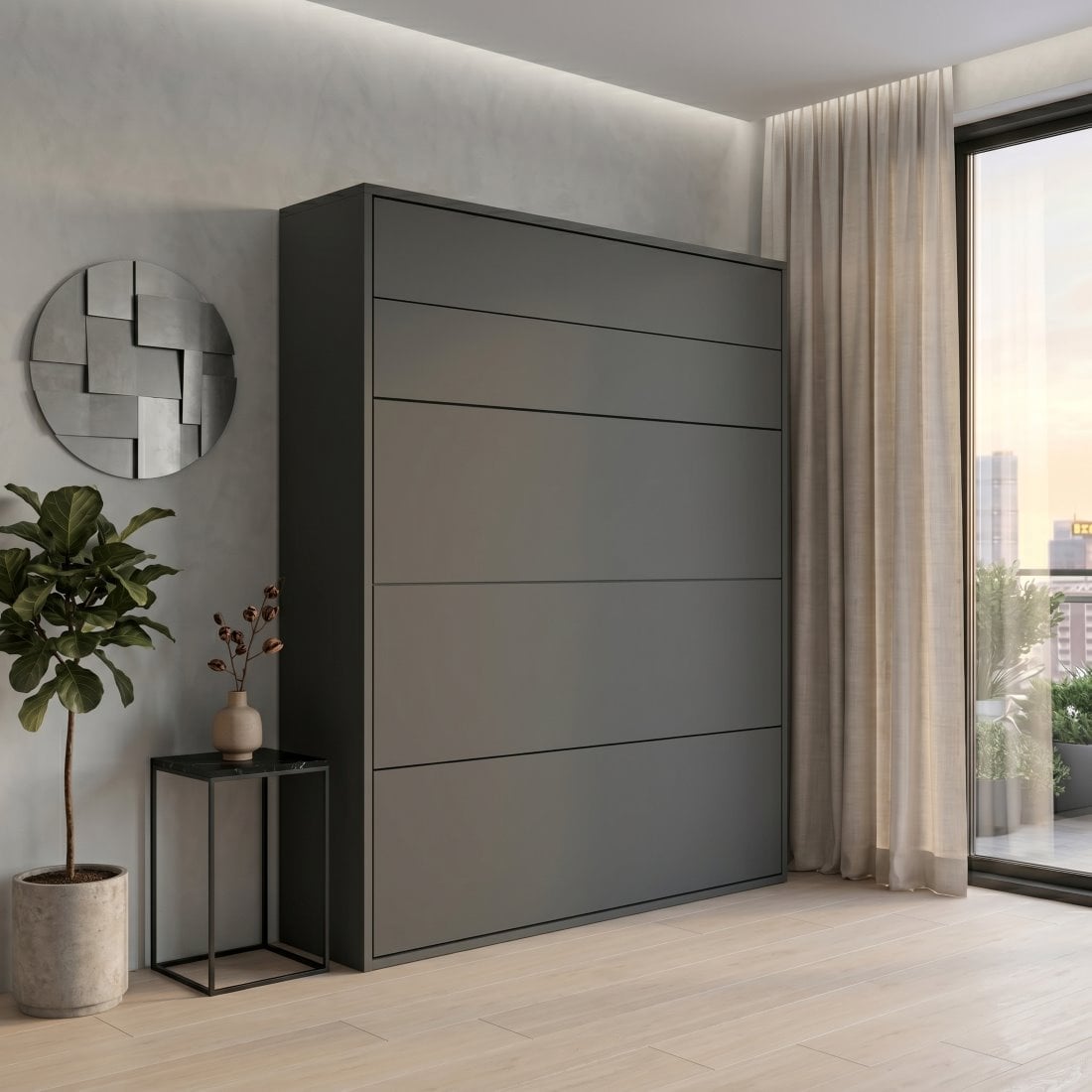 Tall gray wardrobe in a minimalist bedroom next to a potted plant and round metallic wall art on a light wall.