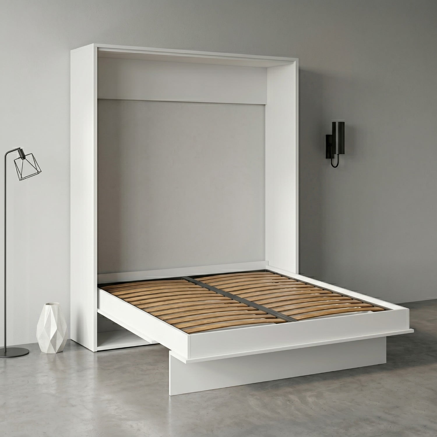White modern platform bed with a pull-out storage extension and wooden slats, in a minimalist gray room with a wall sconce and decorative lamp nearby.